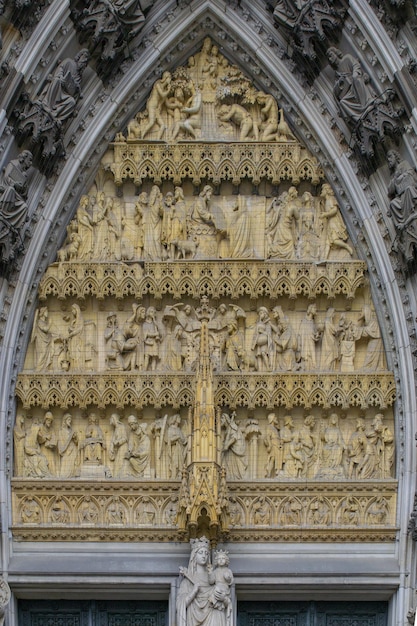 Una grande porta riccamente scolpita con una croce in alto.