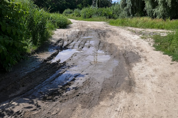 Una grande pozzanghera su una brutta strada ai box.