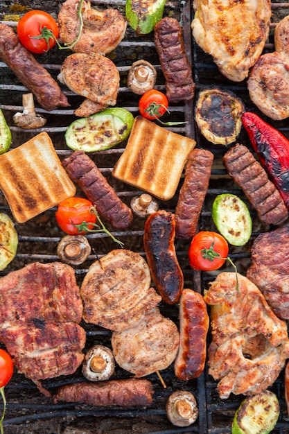 Una grande varietà di carne alla griglia sul fuoco all'esterno