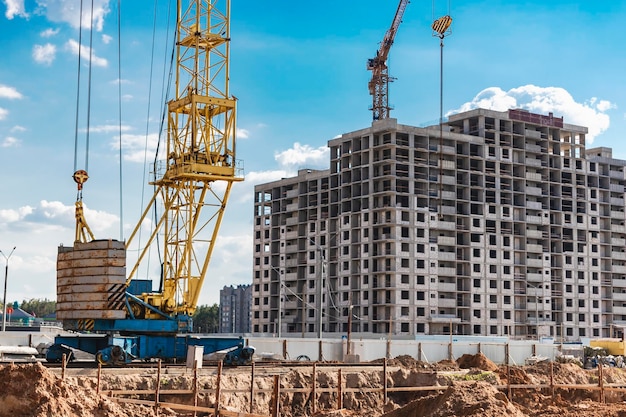 Una gru a torre assembla pannelli di gronda durante la costruzione di una casa a pannelli Costruzione di alloggi moderni Ingegneria industriale Costruzione di alloggi ipotecari