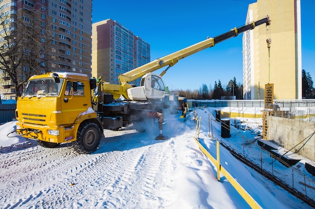 una gru da cantiere lavora in un cantiere con un carico