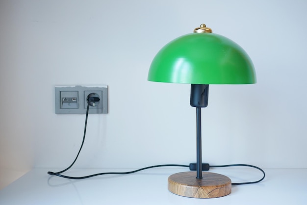 Una lampada da tavolo in casa contro il muro bianco