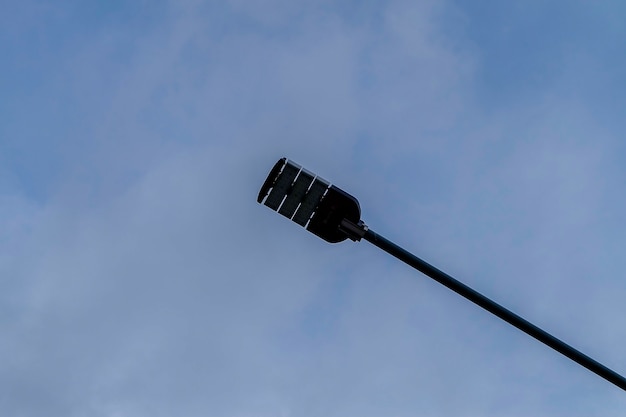 Una lampada di illuminazione stradale su un palo sullo sfondo della nuvola del cielo blu