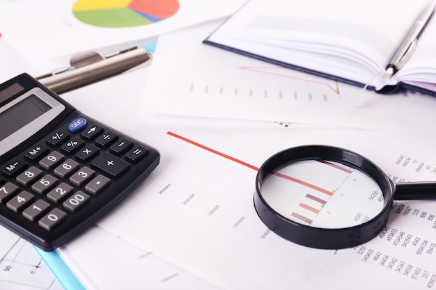 Una lente d'ingrandimento sullo sfondo dei documenti finanziari