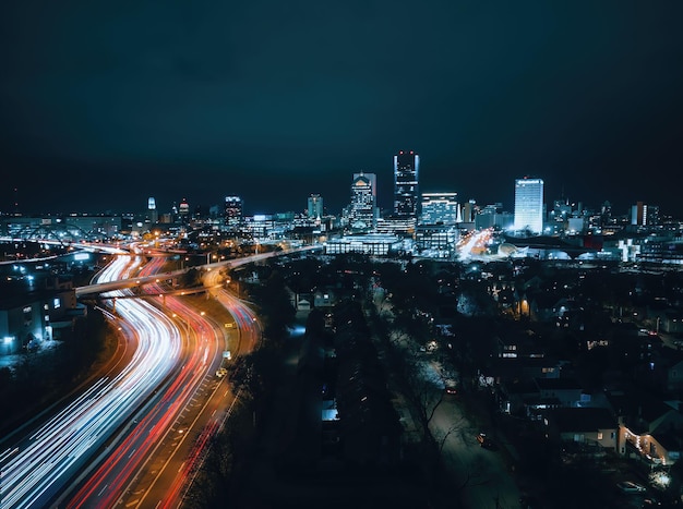 Una lunga esposizione del drone di un paesaggio urbano con luci vibranti che escono dai grattacieli di notte