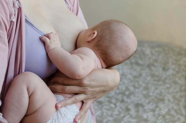 Una madre allatta un neonato primo piano in camera da letto Luce soffusa allattamento al seno c