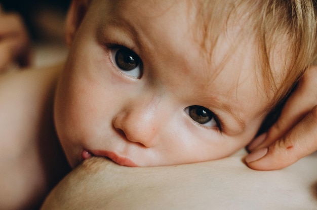 Una madre che allatta al seno il suo bambino in braccio da vicino mamma che allatta e allatta un bambino piccolo