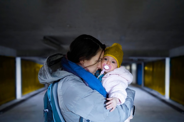 Una madre che tiene il suo bambino spaventato nel rifugio antiaereo