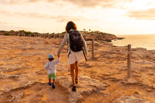 Una madre con suo figlio al tramonto nella spiaggia di Cala Comte sull'isola di Ibiza Baleari