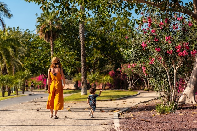 Una madre con suo figlio in vacanza per i cristiani da un parco con palme sull'isola di Tenerife Canarie