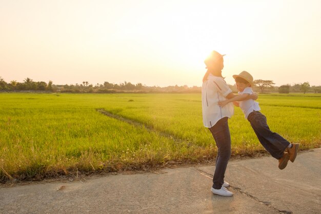 Una madre e un figlio che giocano all&#39;aperto al tramonto