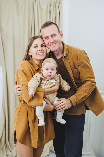 Una madre e un padre felici tengono in braccio il loro figlio di 4 mesi Foto di famiglia di genitori felici con un neonato Concept di famiglia