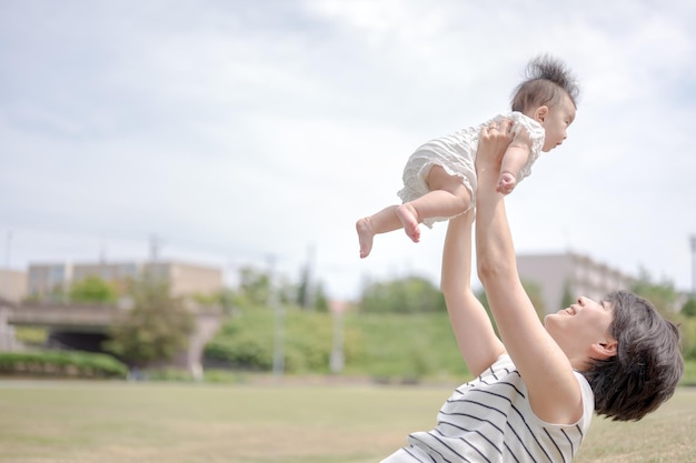 Una madre lancia in aria il suo bambino.