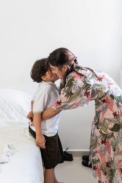 Una madre latina prepara il figlio per la scuola a casa