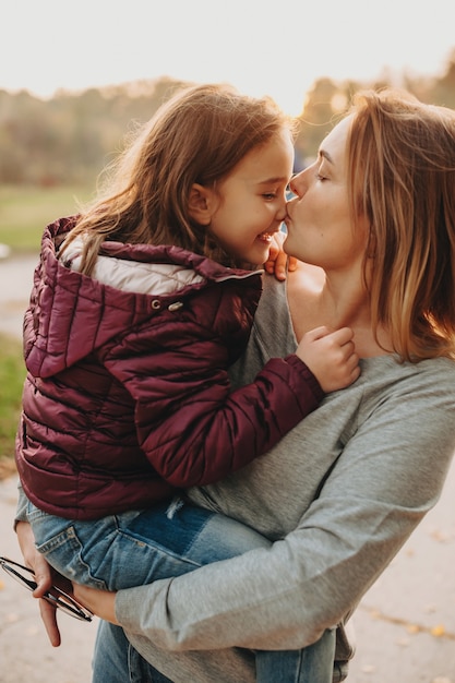 Una madre meravigliosa che bacia la sua piccola figlia dopo averla portata all'asilo