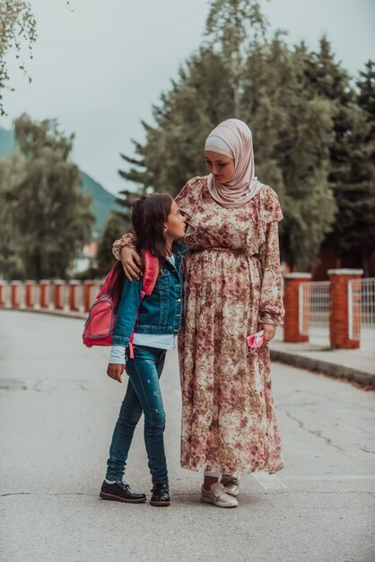 Una madre musulmana torna da scuola con la figlia Messa a fuoco selettiva Foto di alta qualità