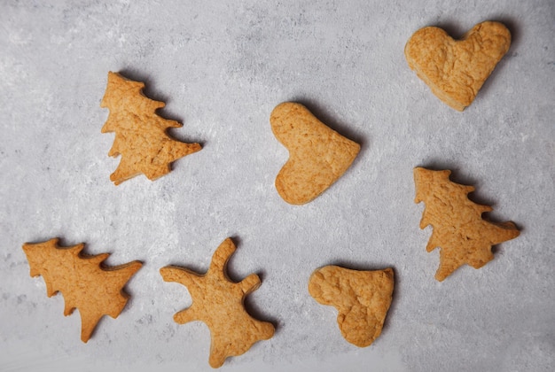 Una manciata di biscotti di Natale su uno sfondo grigio. Disposizione piatta. Vista dall'alto. Concetto di Natale e Capodanno. cucinando