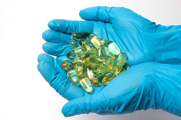 Una manciata di capsule gialle di omega3 nelle mani dell'uomo