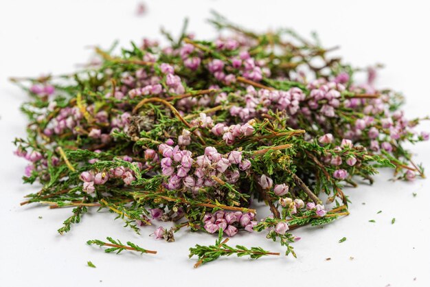 Una manciata di fiori di erbe di erica su uno sfondo bianco erboristeria alternativa