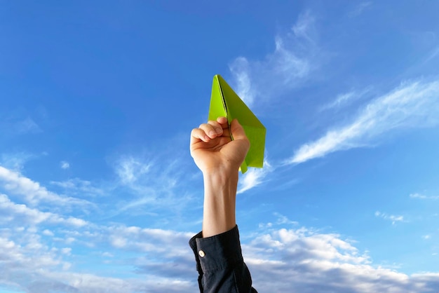 Una mano che tiene un aeroplanino di carta come segno di inizio di un viaggio da sogno