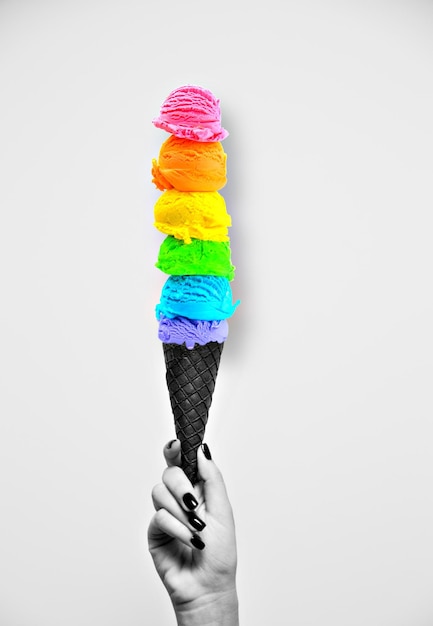 Una mano che tiene un cono gelato arcobaleno