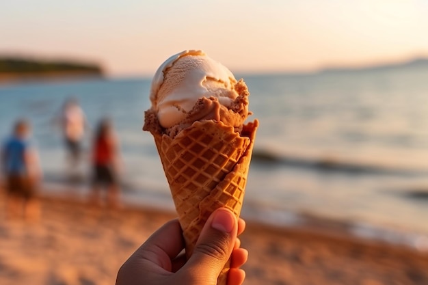 Una mano che tiene un cono gelato con la spiaggia sullo sfondo