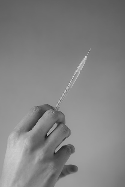 una mano con un ago per iniezione