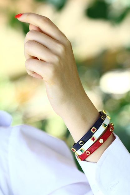 Una mano con un braccialetto rosso, blu e giallo.