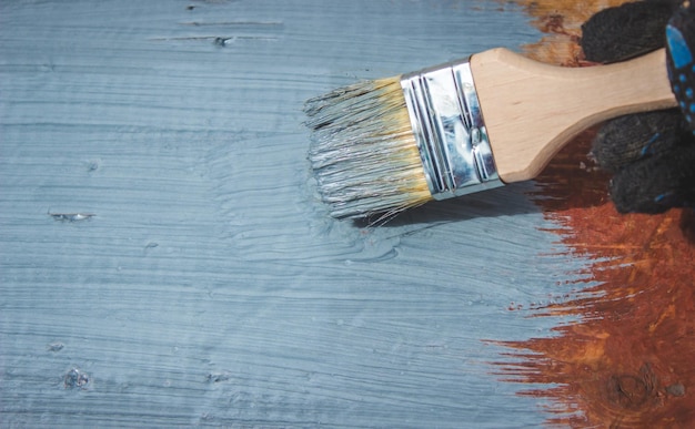 Una mano con un pennello che dipinge di grigio un albero