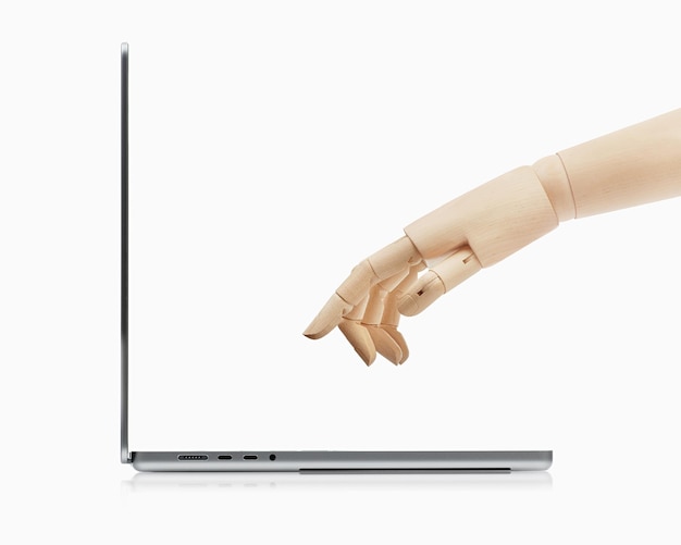 Una mano di legno raggiunge la tastiera di un laptop Tecnologia di intelligenza artificiale