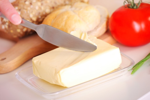 una mano femminile che imburra del pane in cucina