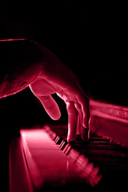 Una mano maschile sul pianoforte Un classico fresco per il 2023 nel concetto Viva Magenta Color of the year