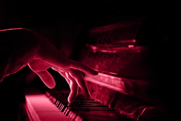 Una mano maschile sul pianoforte Un classico fresco per il 2023 nel concetto Viva Magenta Color of the year