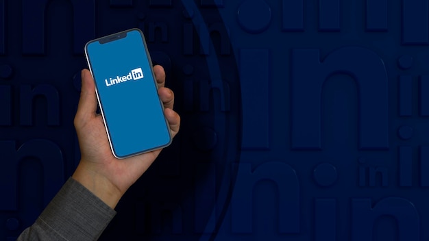 Una mano maschile tiene uno smartphone con il logo Linkedin sullo schermo