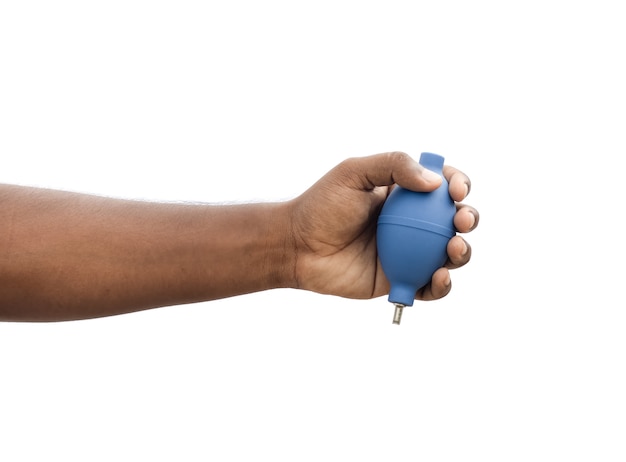 Una mano maschio che tiene un ventilatore per la pulizia della fotocamera in un pugno su sfondo bianco isolato