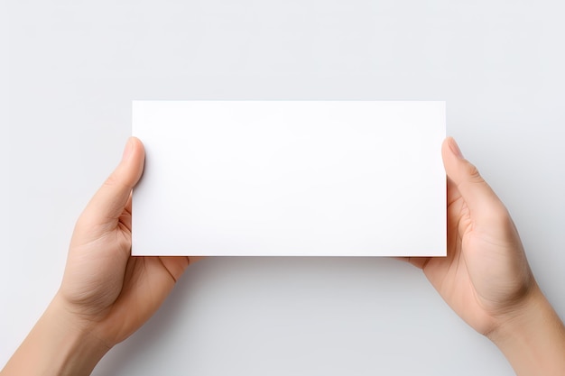 Una mano umana che tiene un foglio bianco di carta bianca o carta isolata su sfondo bianco