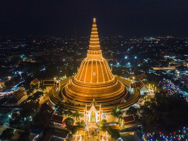 Una massiccia pagoda dorata Situata nella comunità al tramonto di Phra Pathom Chedi Nakhon Pathom Thailandia La misurazione è stata resa pubblica Thailandia Veduta aerea di una rotatoria stradale con lotti di auto