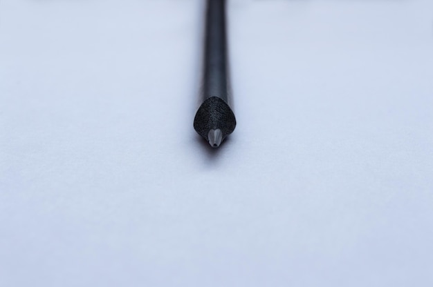 Una matita nera giace su un foglio di carta bianca