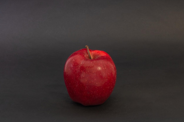 Una mela rossa su sfondo nero