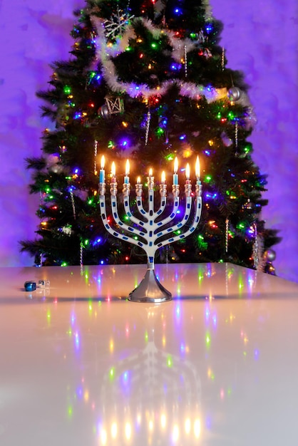 Una menorah di Hanukkah illuminata da candele su un tavolo sfocato