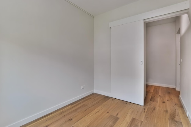 Una meravigliosa stanza vuota con pavimento in legno e pareti bianche