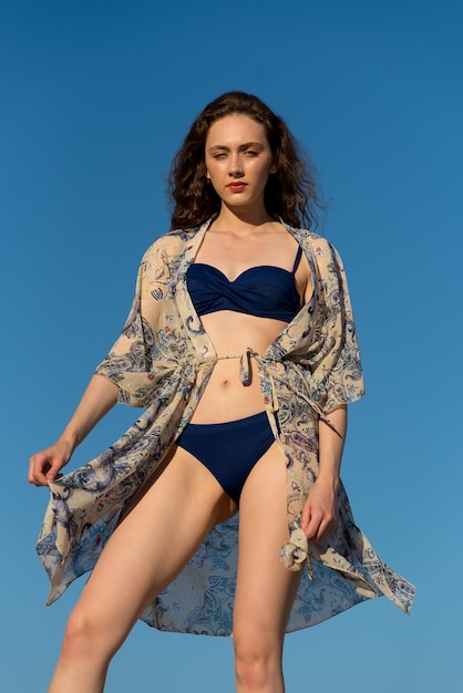 Una modella indossa un bikini blu con motivo floreale sul davanti.