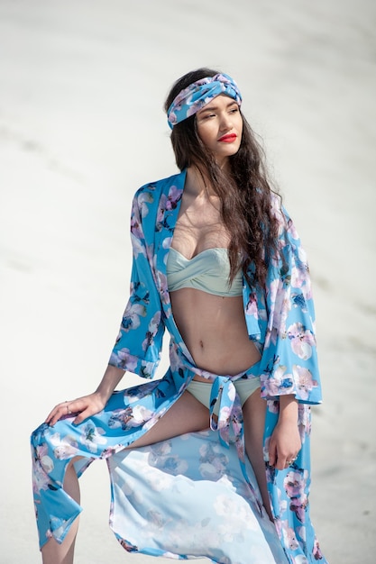 Una modella indossa un kimono blu con una stampa floreale.