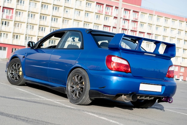 Una moderna auto sportiva blu da corsa veloce in pista il giorno delle prove estive