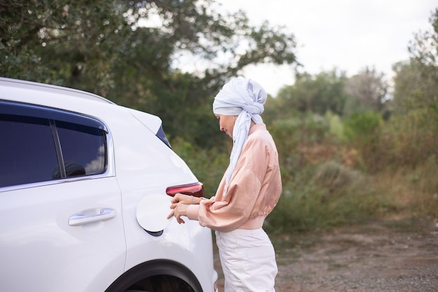 Una moderna donna musulmana sta aprendo il coperchio della sua auto