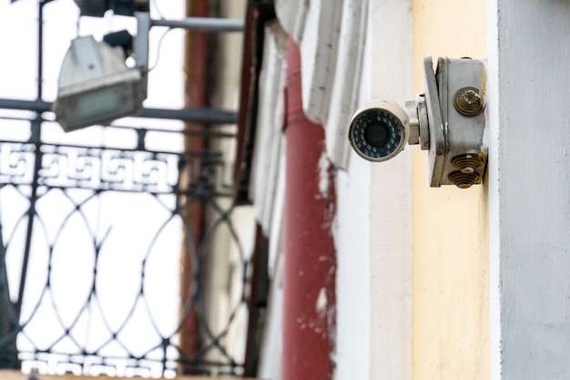 Una moderna telecamera di sorveglianza montata sulla parete di un edificio custodito in primo piano Sistemi di sicurezza e protezione dai furti Protezione del sistema bancario del territorio privato e degli effetti personali