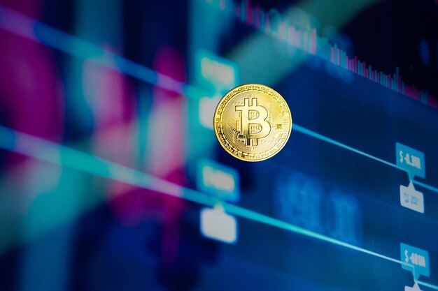 Una moneta Bitcoin dorata con il grafico del mercato azionario finanziario sullo sfondo Moneta di criptovaluta Mercato finanziario