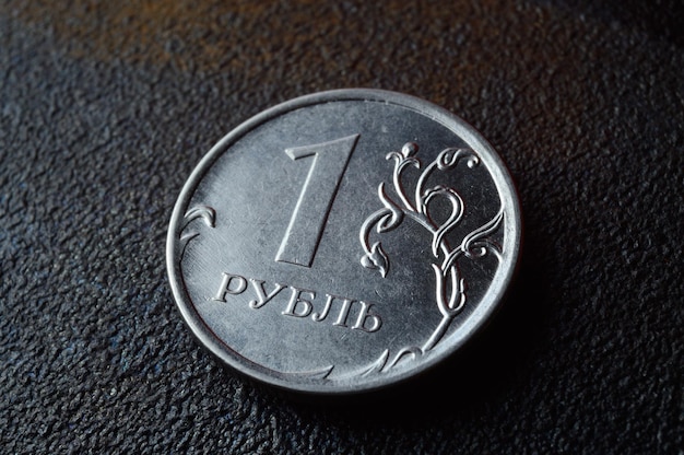 Una moneta da un rublo russo giace su uno sfondo di metallo scuro. avvicinamento.
