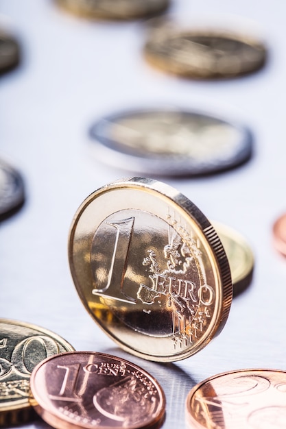 Una moneta in euro sul bordo Monete in euro impilate l'una sull'altra in posizioni diverse