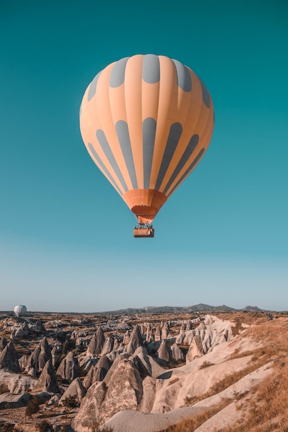 Una mongolfiera arancione nel cielo blu del mattino